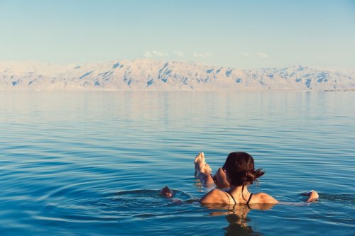 Female Tourist Floating In The Dead Sea In Israel