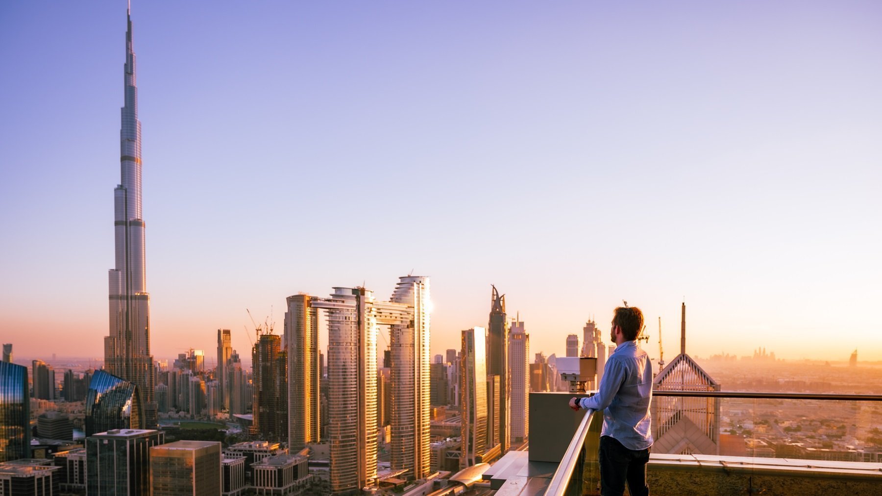 Man Overlooking Dubai Skyline At Sunset