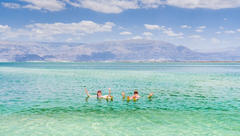 Couple Floating In The Dead Sea Israel