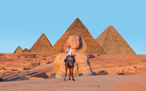 Tourist On Camel Standing Front Of Sphinx Giza Pyramids